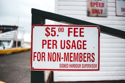 Close-up of a sign indicating a $5 usage fee for non-members at a harbor.